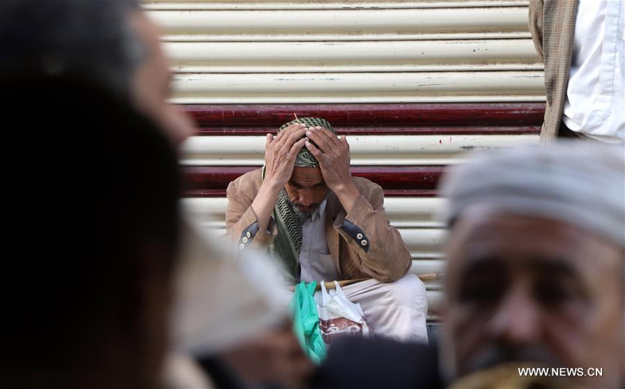 رجل يمني من المتضررين بأكثر من 4 أعوام من الصراعات ينتظر دوره لاستلام خبز مجاني