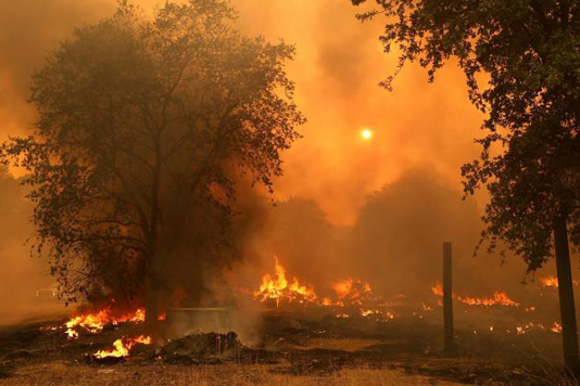 Thousands flee as fast-moving wildfires spread in California