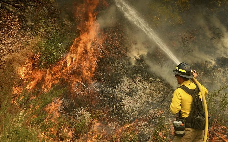 US wildfires: 16 dead as cool weather brings hope